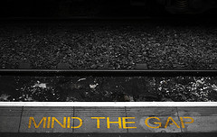 Mind the gap warning next to railroad tracks.