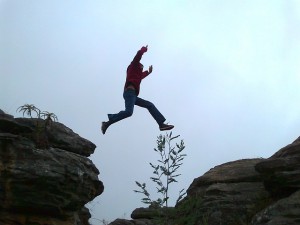 person leaping across rocks