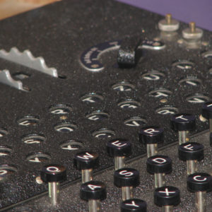 Close-up of Enigma code machine with keys and rotors.