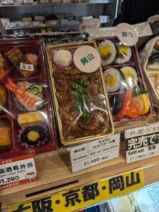 Detailed plastic replicas of the Japanese food that a restaurant offers to the right of a menu in Japanese (menu not pictured). 