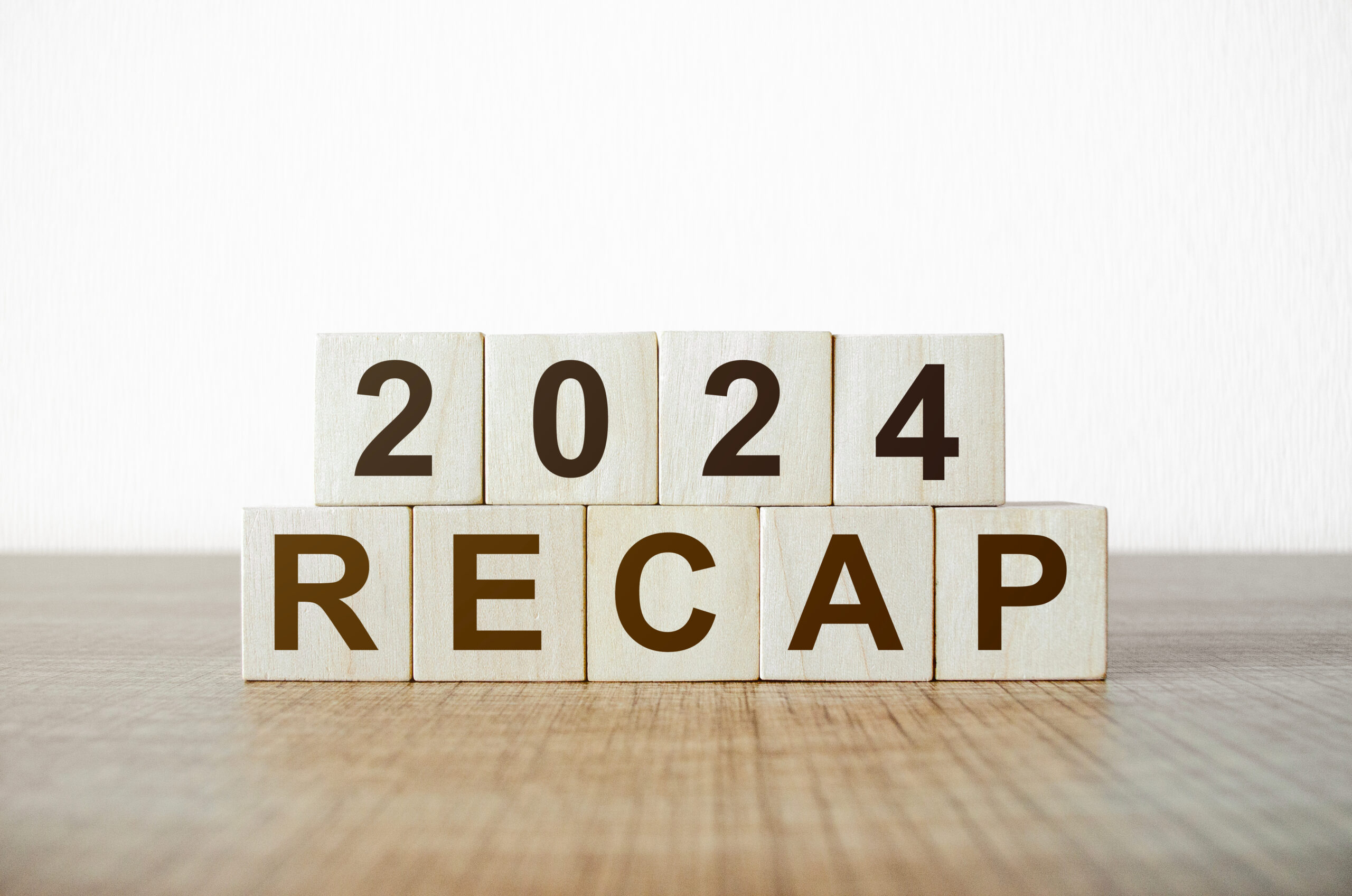 Wooden blocks arranged on a wooden surface, with the top row spelling "2024" and the bottom row spelling "RECAP," symbolizing a review of the content we wrote in 2024.